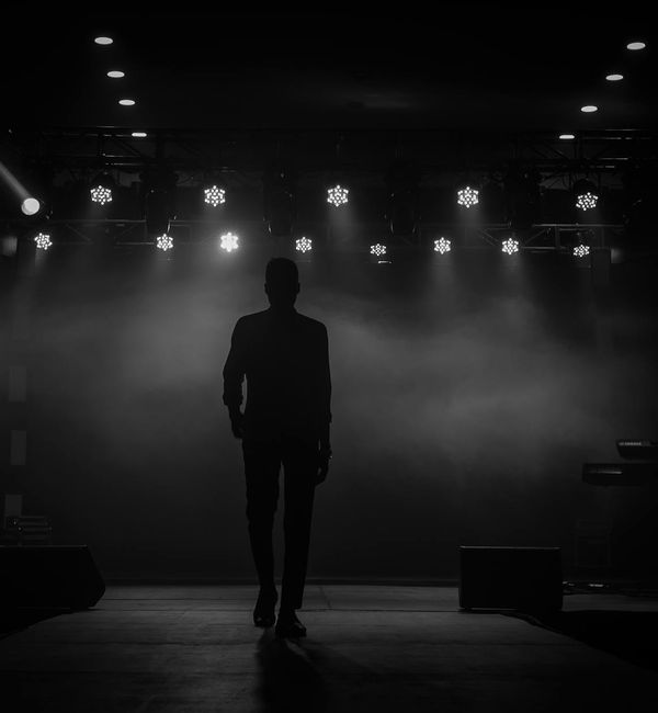 Silhouette of a person meditating against a dark background.